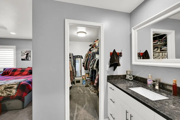 Bathroom vanity with a rectangular sink and dark granite countertop