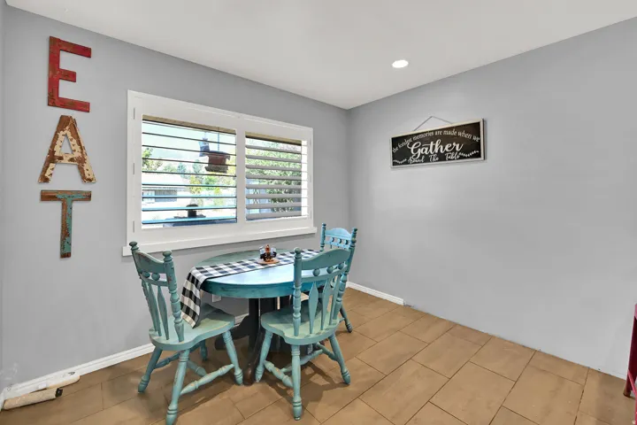 Recessed ceiling lighting, window with plantation shutters, light gray wall finish, and wood-finish flooring