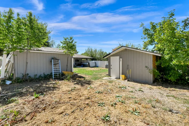 Two detached storage sheds with sloped roofs and light-colored siding