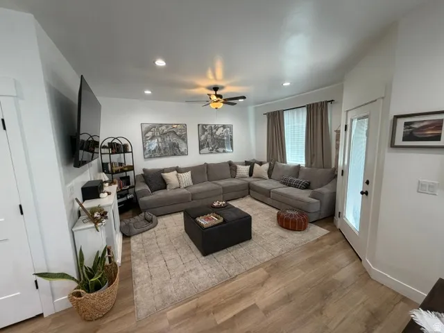 Recessed lighting, wood-finish flooring, ceiling fan, and white trim