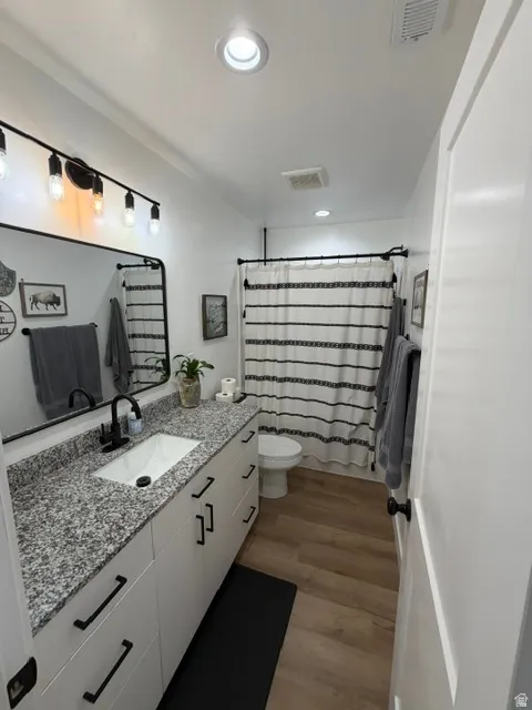 White vanity with matte black hardware, granite-patterned countertop, and an undermount sink