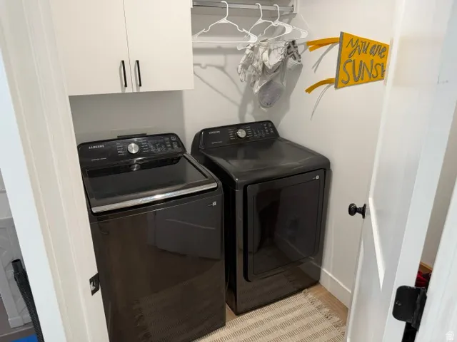 Built-in overhead white cabinetry with black hardware, and a clothes hanging rod