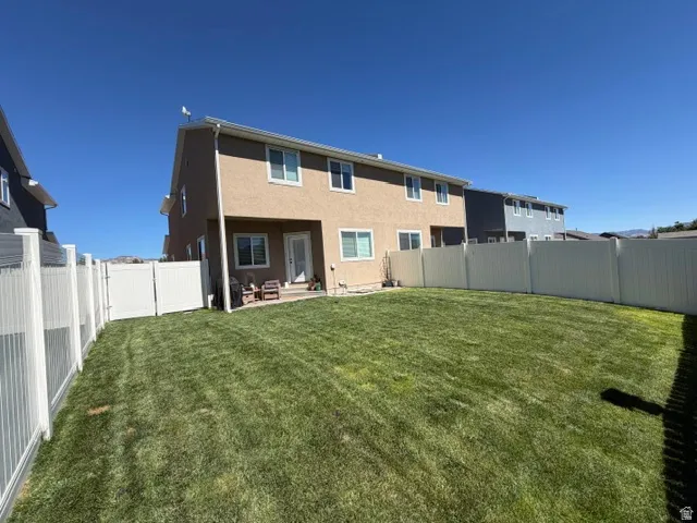 Expansive green lawn enclosed by privacy fencing with a gate
