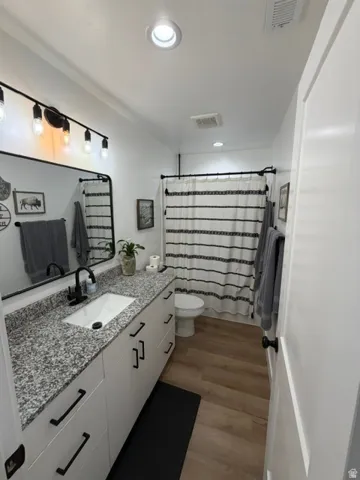 White vanity with matte black hardware, granite-patterned countertop, and an undermount sink