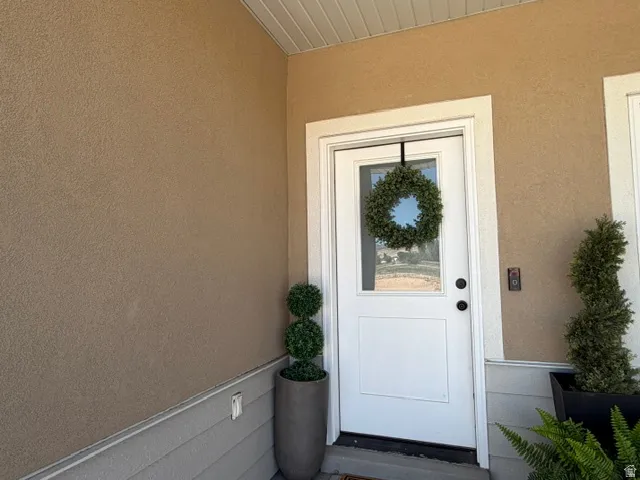 Stucco exterior with a white entry door featuring a glass insert