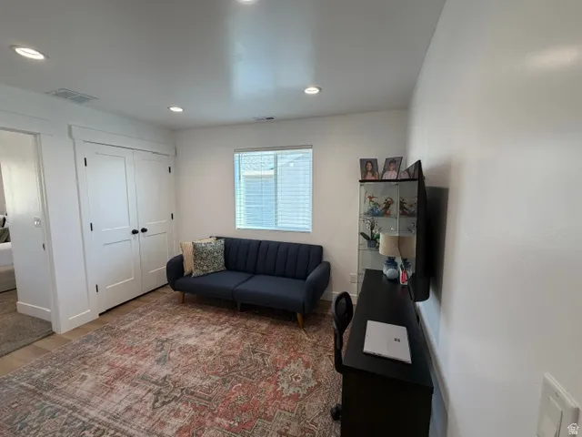 White walls with recessed lighting, double-door closet, and a window with blinds