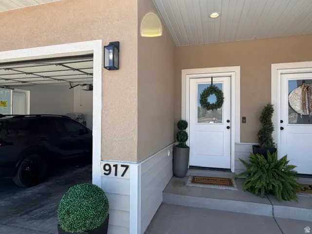 Stucco exterior with white trim, recessed lighting, and an overhead garage door