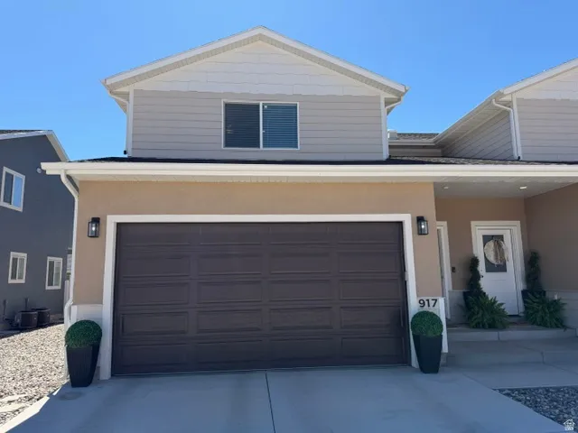 Two-story stucco and siding exterior with a two-car garage and a paved driveway