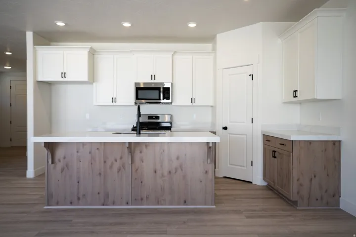 Terrific kitchen with 42" painted white wood uppers, stained wood cabinets and island, gas range, microwave, dishwasher and disposal.