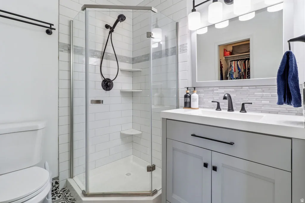 Step-in shower with a glass enclosure, white subway tile surround, and built-in shelving