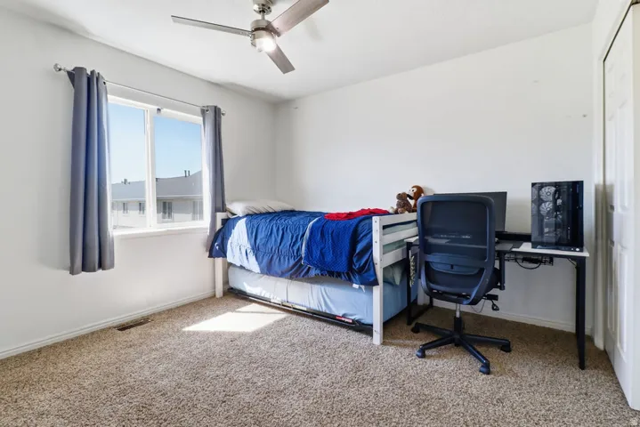 Recessed lighting, ceiling fan, white walls, carpet flooring, and a white interior door