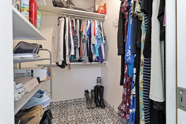 Patterned tile flooring, multiple hanging rods, and built-in shelving