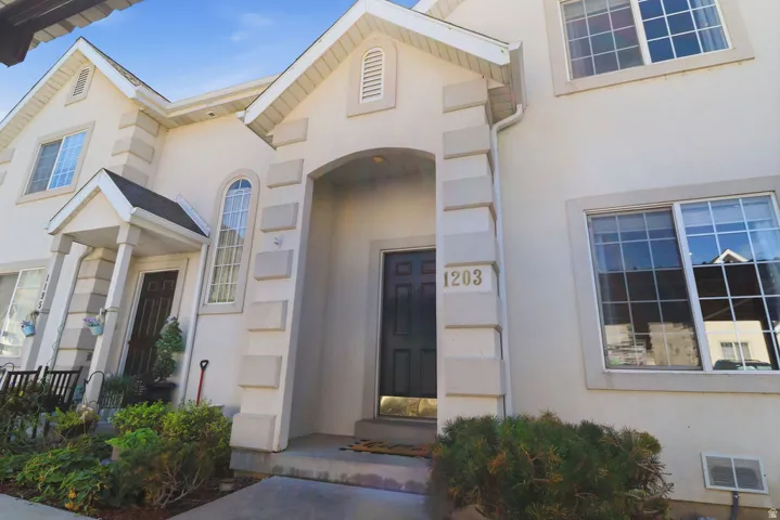 Stucco exterior with stone-look accents, covered entry, and multi-pane windows