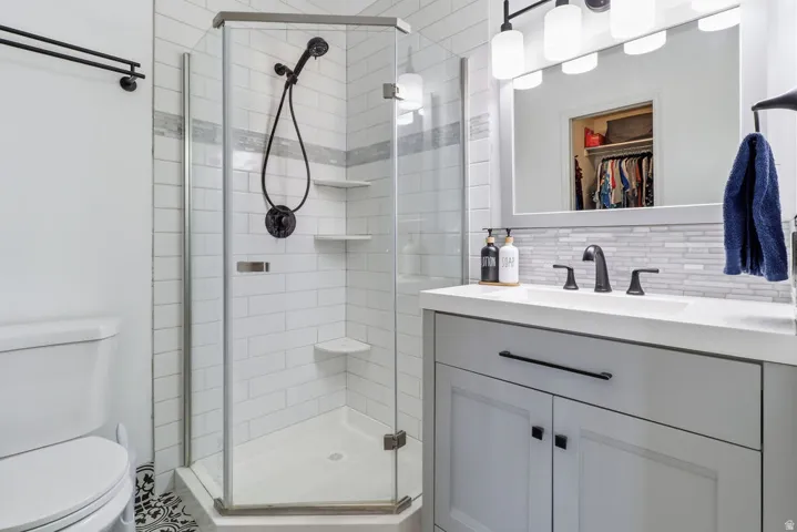 Step-in shower with a glass enclosure, white subway tile surround, and built-in shelving