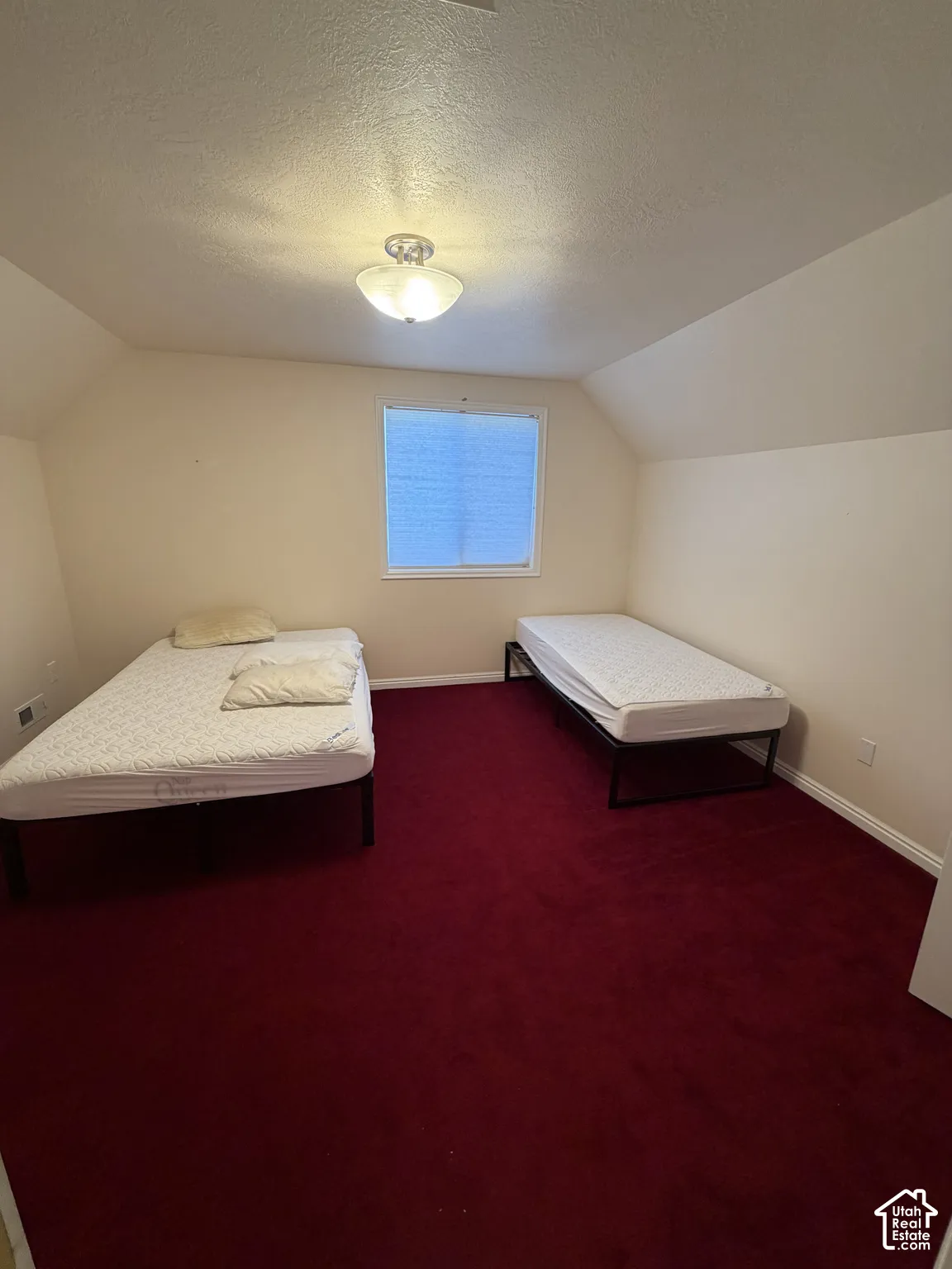 Room featuring a window with blinds, a ceiling-mounted light fixture, sloped ceiling details, and red carpeting