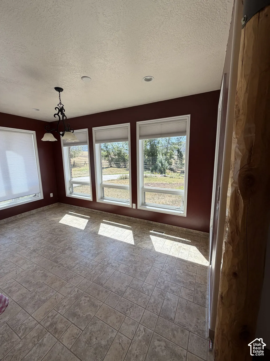 Room featuring tiled flooring, multiple windows, recessed lighting, and a decorative ceiling fixture