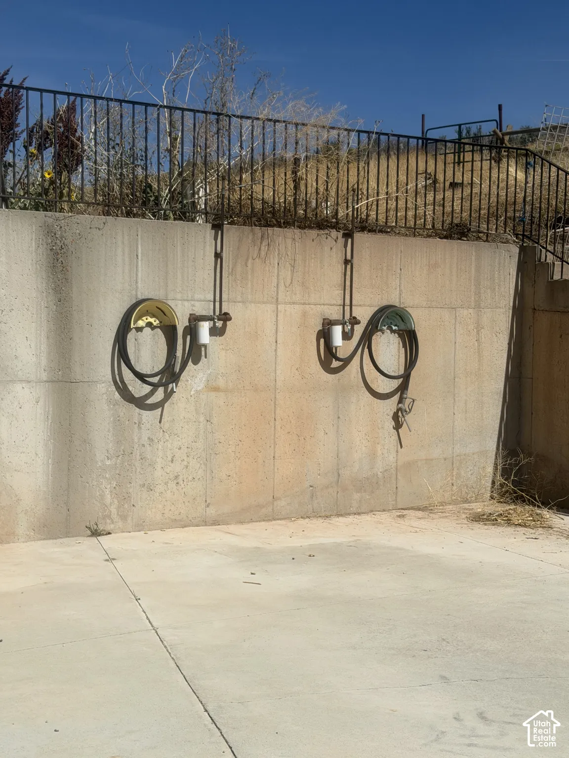 Concrete retaining wall with metal fencing