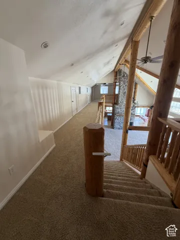 Spacious loft area featuring sloped ceilings, recessed lighting, and a neutral carpeted floor