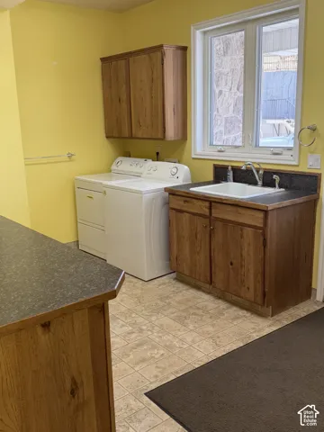 Built-in cabinetry with wood-finish doors, utility sink with countertop, and window with white trim