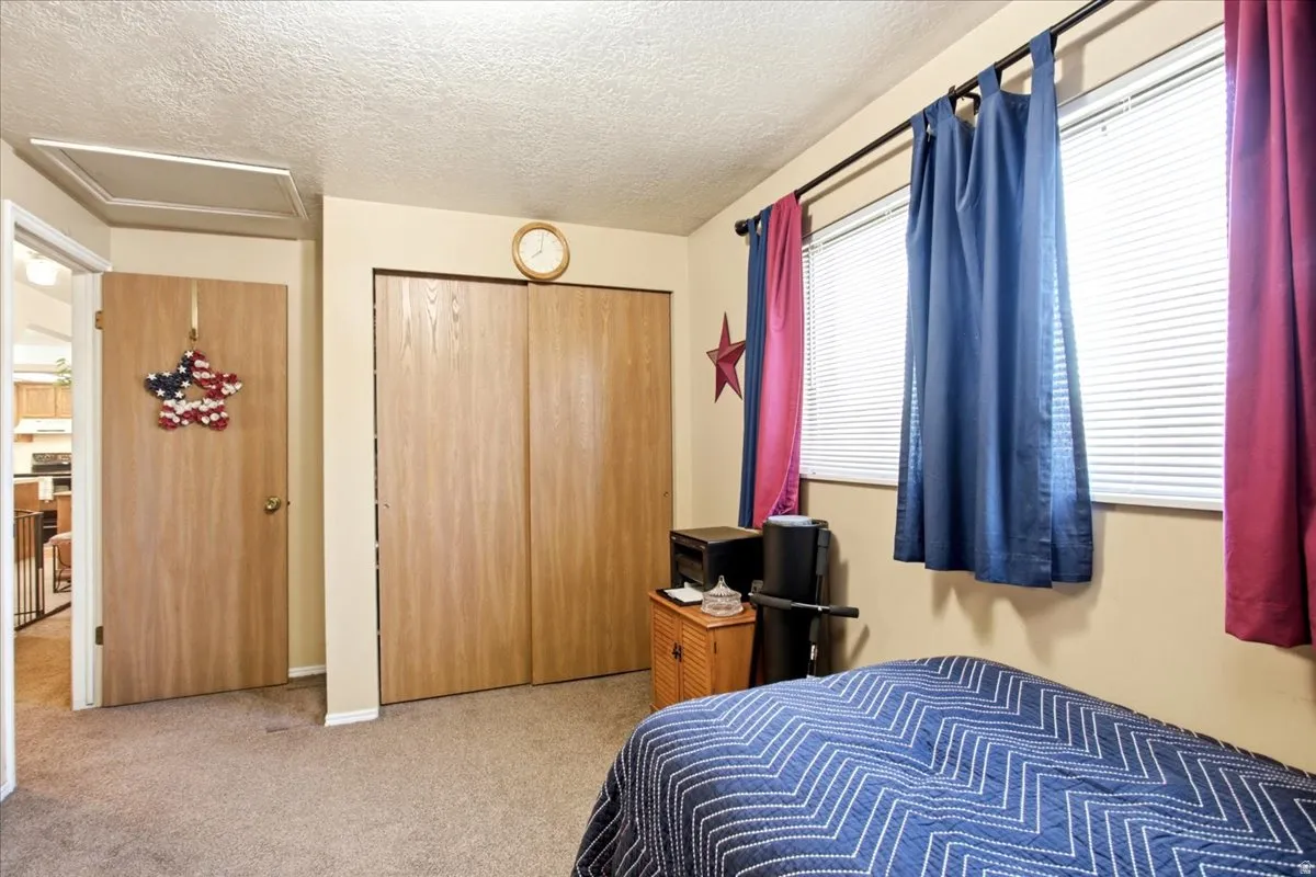 Built-in closet with bi-fold doors, two windows, and an overhead access panel
