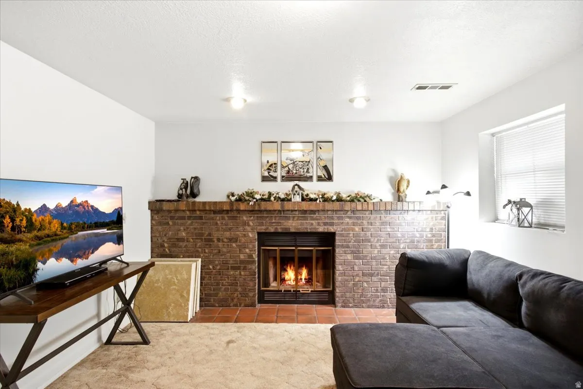 Brick-clad fireplace with an integrated firebox, flanked by a tiled hearth