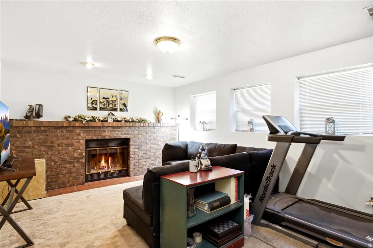 Brick fireplace with a metal insert, tiled hearth, and overhead lighting