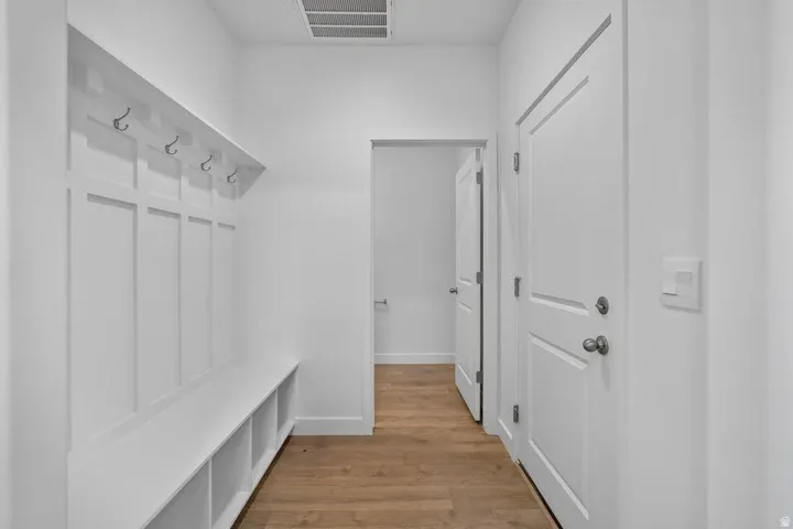 Built-in hall tree with storage bench, integrated wall hooks, and wood-finish flooring