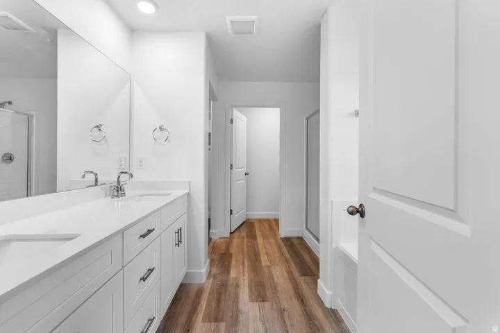 Dual vanity with white shaker-style cabinetry and chrome fixtures