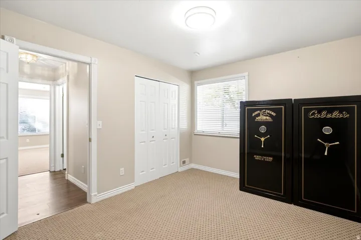 Carpeted flooring, white trim, single window with blinds, bi-fold closet doors, and recessed ceiling lighting