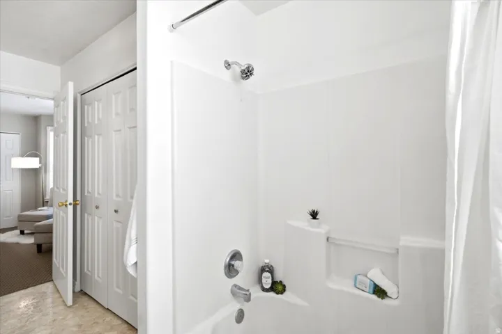 Tub and shower combination with chrome fixtures and integrated shelving