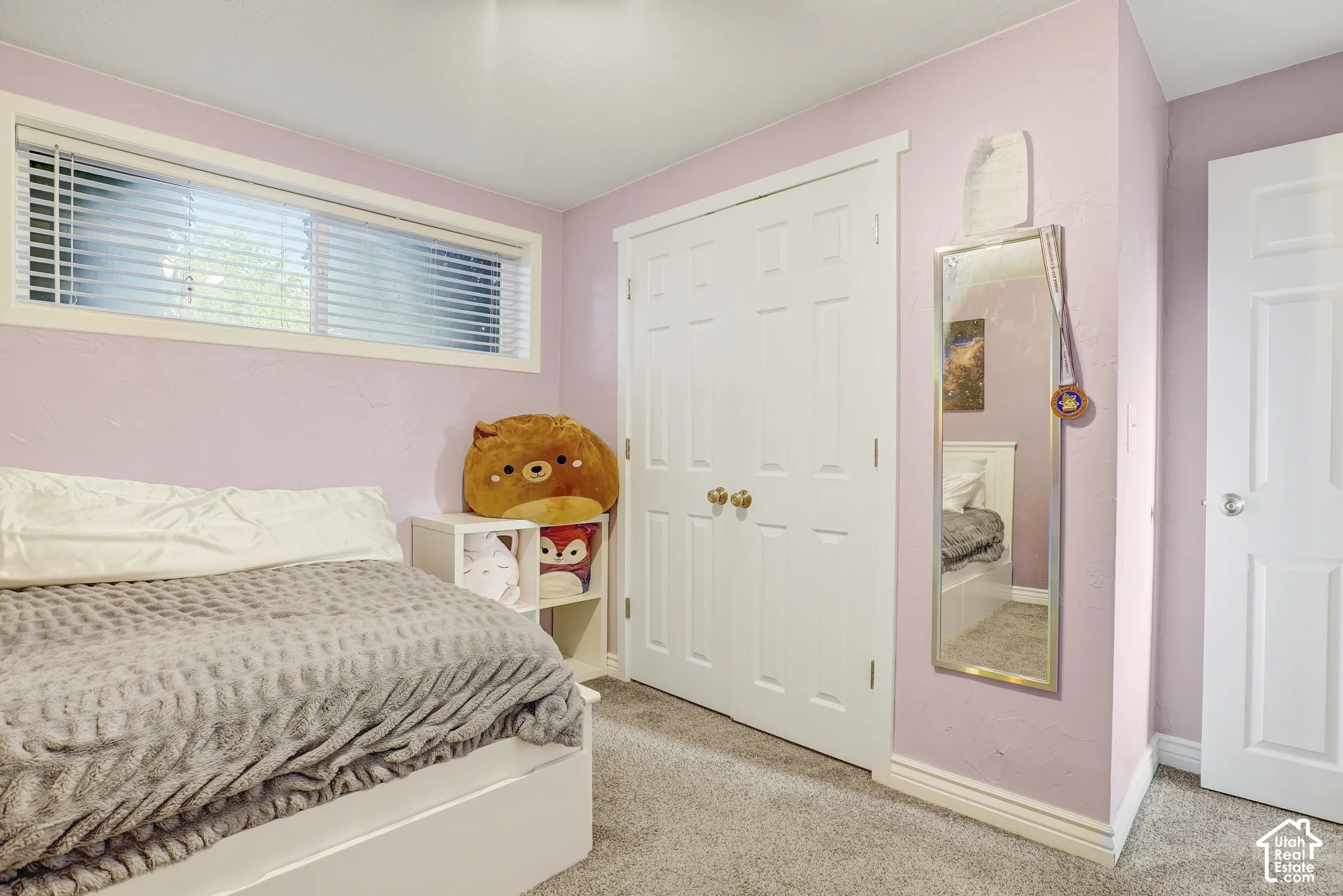 Wall-to-wall carpeting with a low pile, white trim, and a horizontal window with blinds
