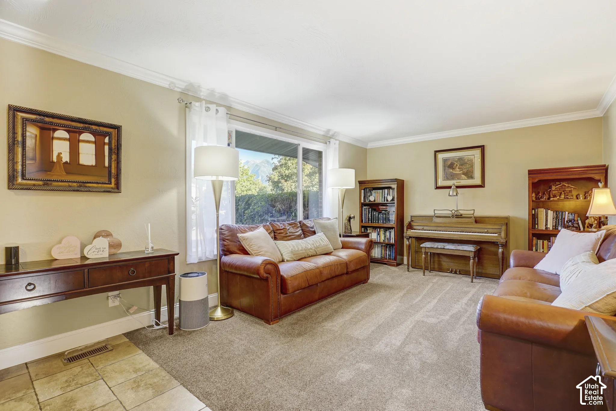 Spacious living area featuring neutral-toned walls, crown molding, and large windows