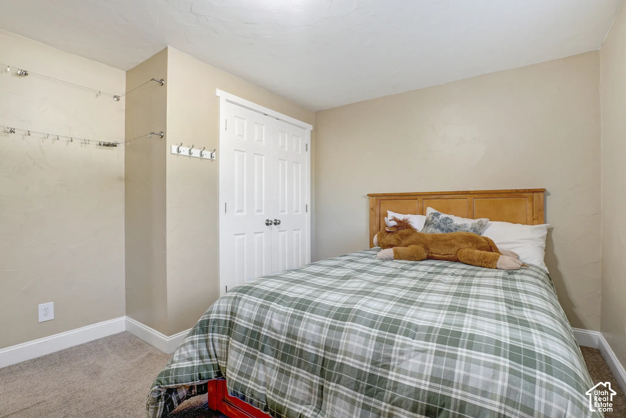 Built-in closet with paneled bifold doors, carpeted flooring, and a wood headboard