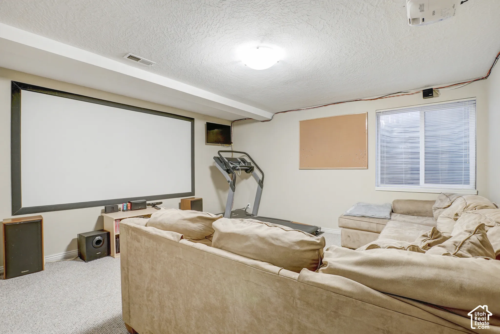 Projection screen and projector, recessed lighting, wall-to-wall carpeting, and a window with blinds
