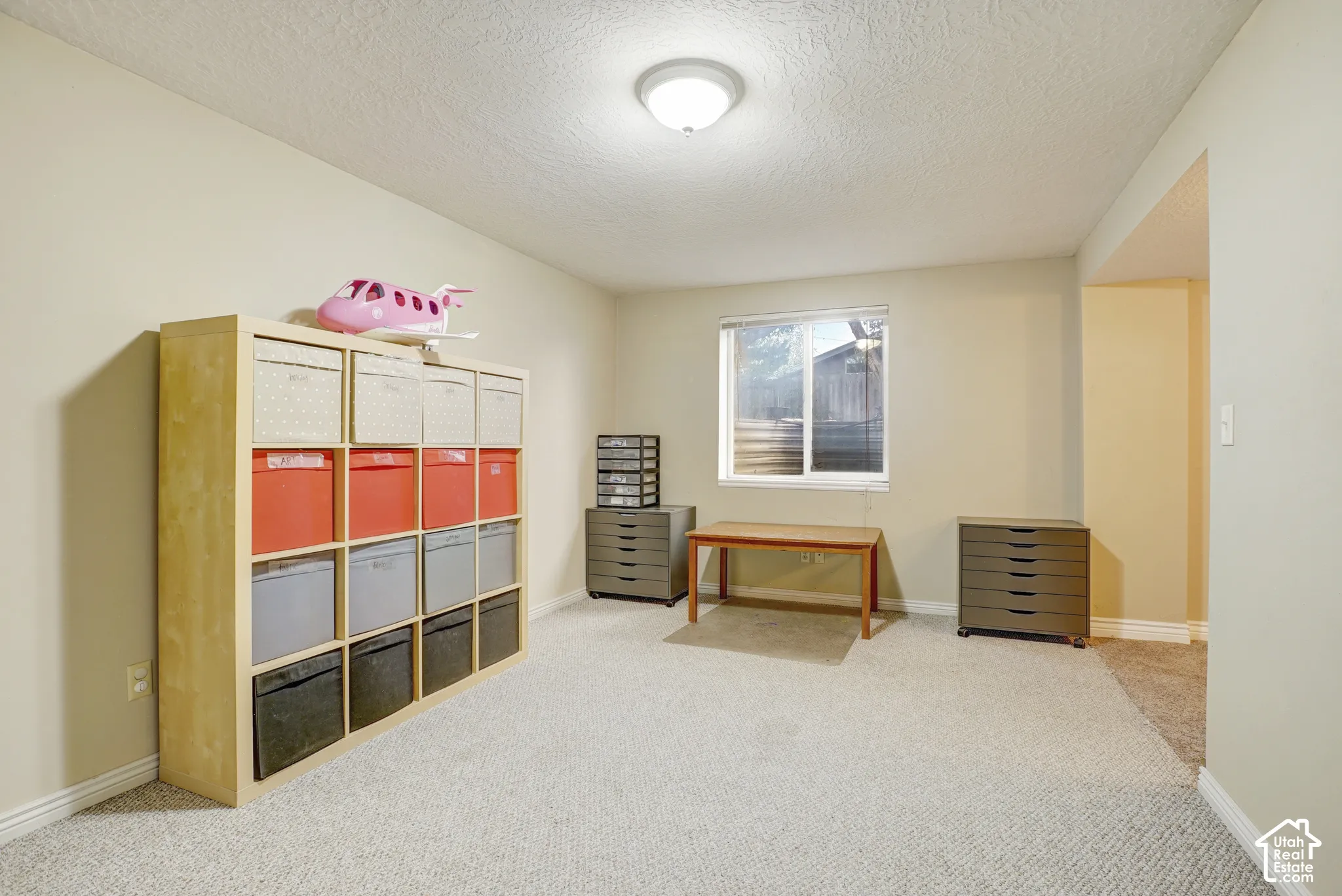 Recessed window, ceiling-mounted light fixture, light-colored walls, light-colored carpeting