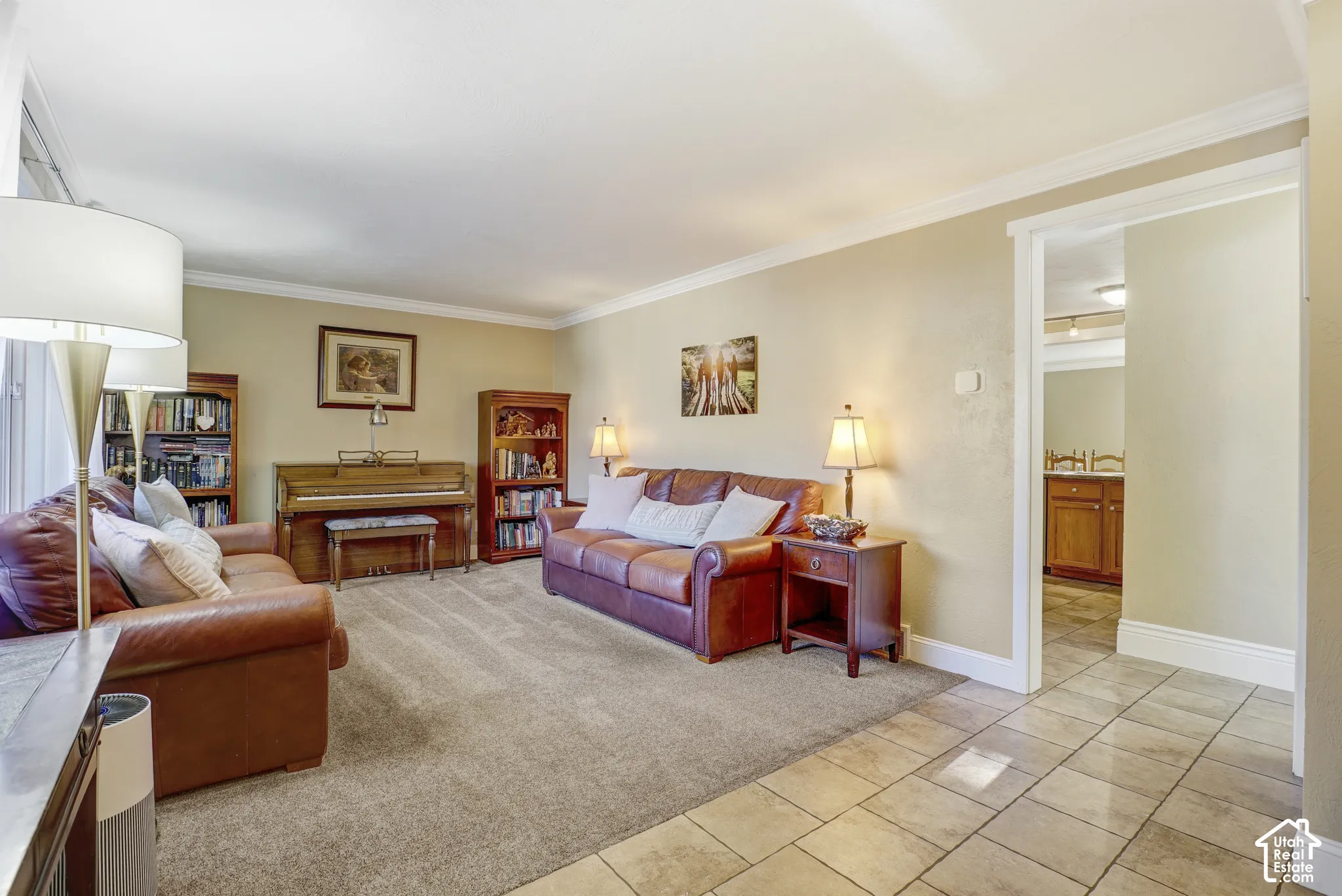 Spacious living area featuring neutral-toned walls, crown molding, and plush carpeting