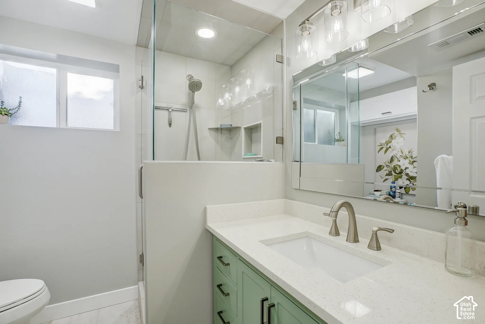Walk-in shower with clear glass enclosure and tile surround