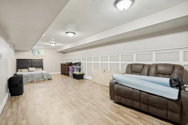 Wood-finish flooring, recessed lighting, and decorative wall paneling