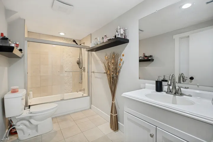 White vanity with a rectangular basin, brushed nickel faucet, and integrated mirror