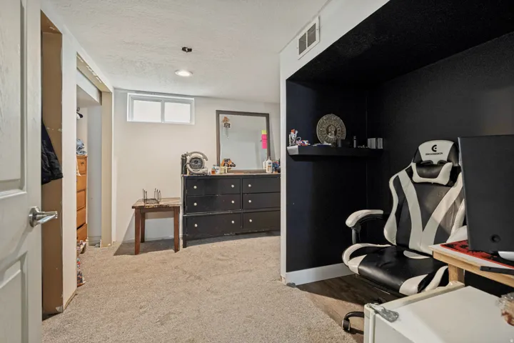 Carpeted flooring, recessed lighting, and a white window frame with obscured glass
