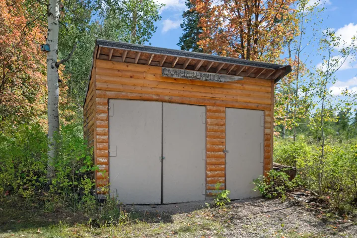 Log cabin-style outbuilding featuring a pitched roof and multiple access doors