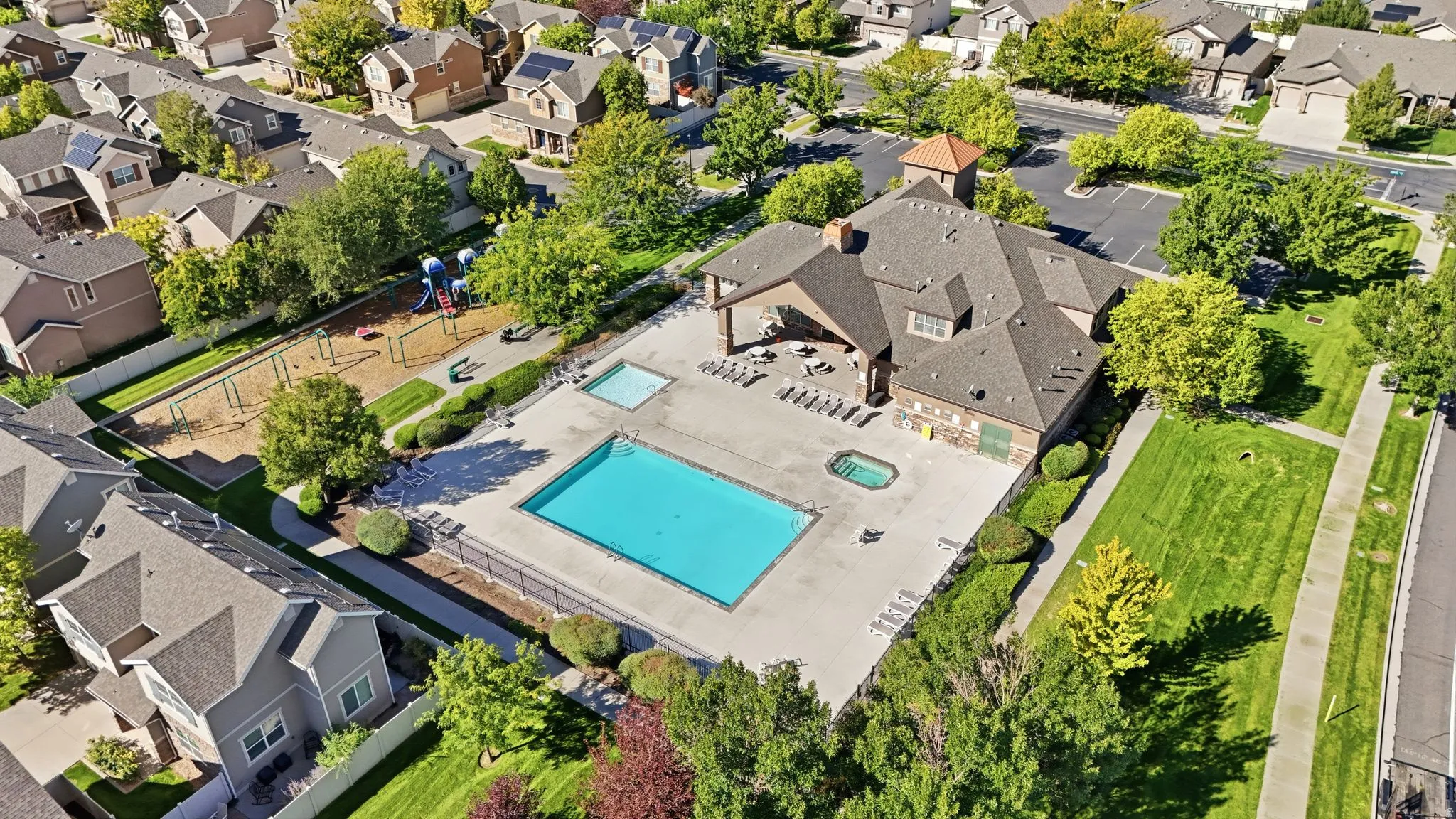 Community recreation center featuring a clubhouse, exercise room, a swimming pool, separate spa, and adjacent playground area.