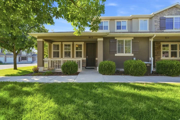 Front exterior with a covered porch, white railing, and multiple windows