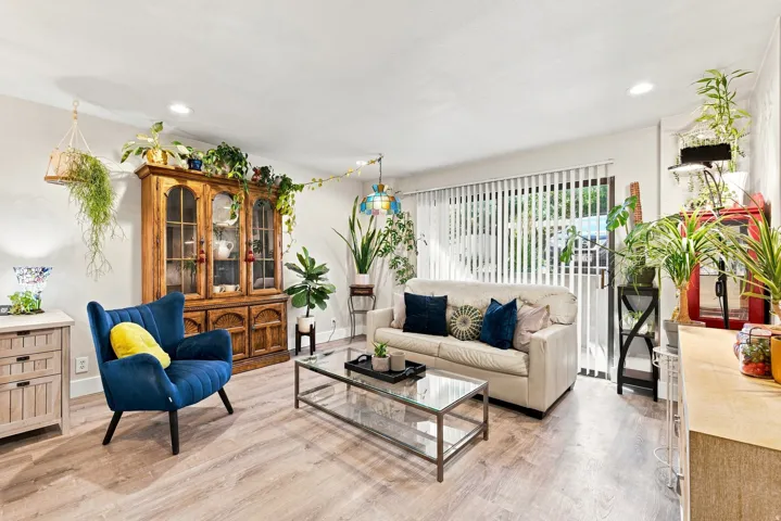 Recessed lighting, wood-finish flooring, sliding glass door with vertical blinds, built-in display cabinet, and neutral wall tones