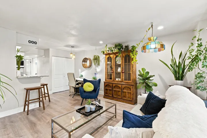 Wood-finish flooring throughout, a pass-through window with a granite countertop, and recessed lighting