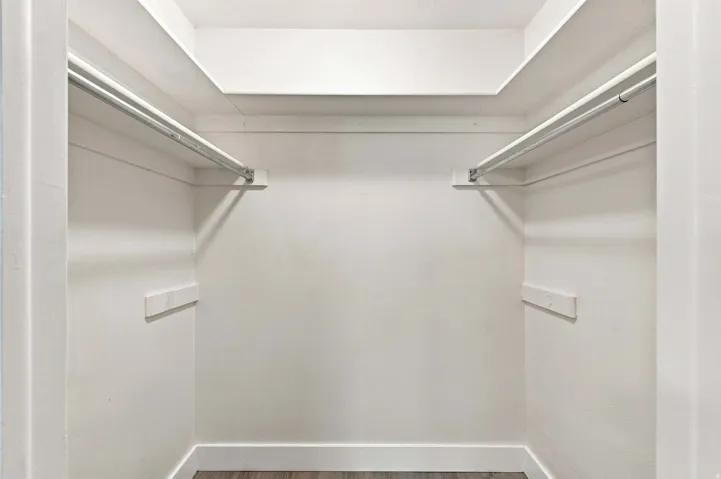 Walk in closet with integrated shelving and dual clothing rods