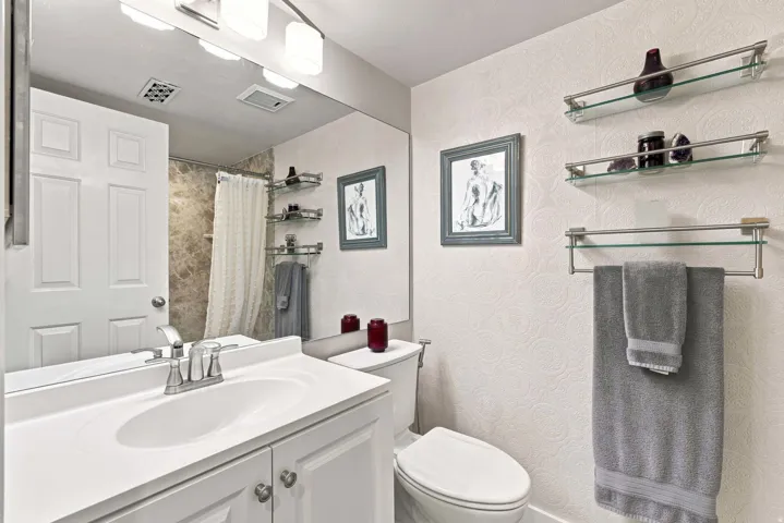 White vanity with a single basin sink and chrome faucet