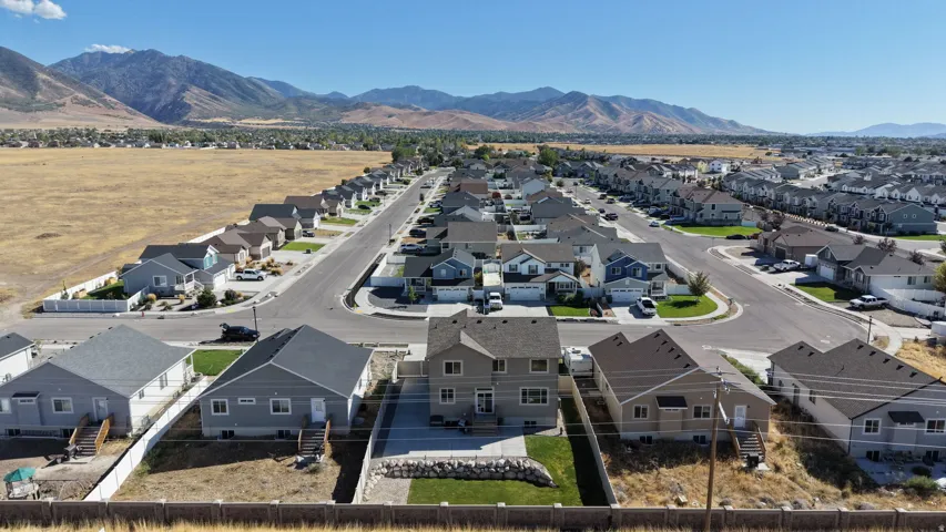 Residential development featuring a grid-pattern street layout, uniformly designed homes, and mountain scenery