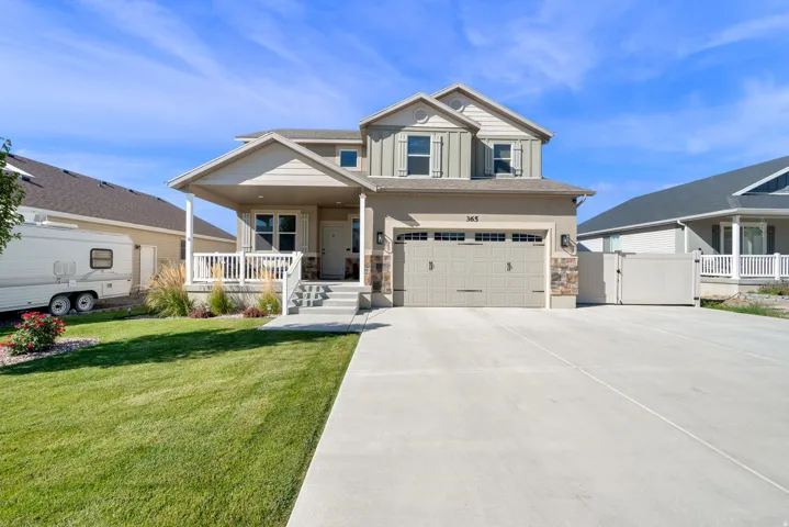 Two-story residence featuring a covered front porch, an attached two-car garage, and a concrete driveway