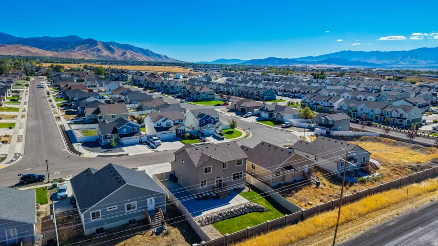 Residential neighborhood with paved streets and sidewalks, featuring a variety of housing styles and mountain scenery